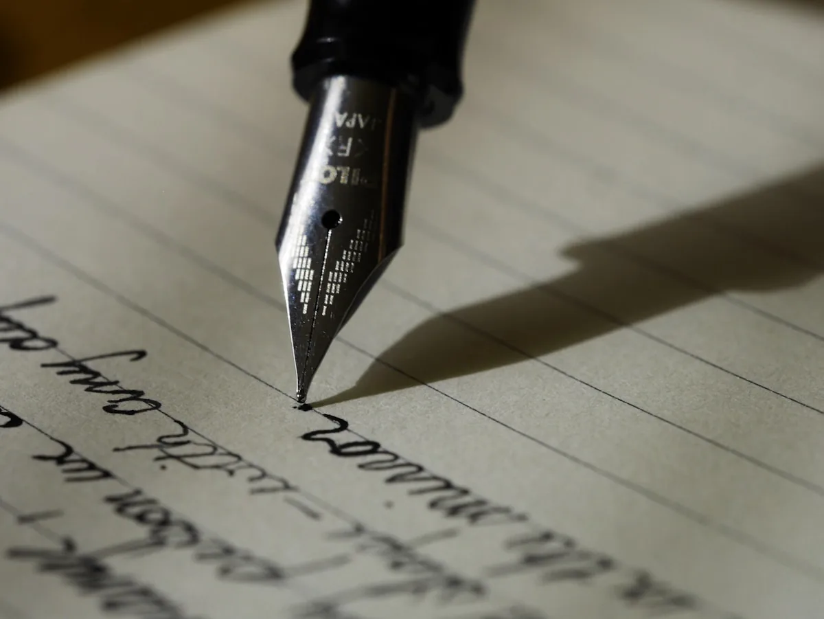 Person writing English notes in a notebook at a desk
