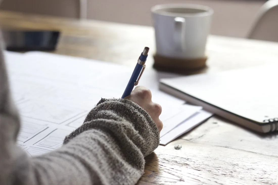 Student making notes while preparing for the IELTS exam